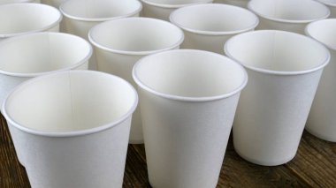 Kahve için beyaz, tek kullanımlık kağıt bardak ya da koyu fonda sıcak içecek. Seçici odaklanma. Yakın plan..