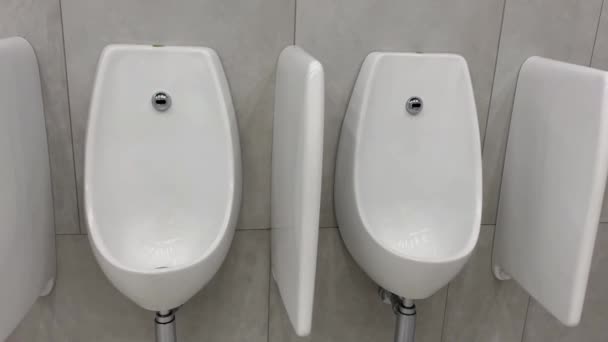 Salle de toilettes rangée intérieure urinoirs à l'intérieur toilettes publiques WC WC pour homme coup de feu à la main. — Video