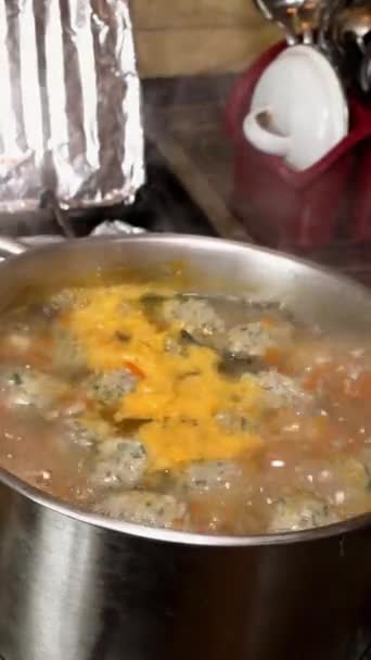 Memasak sup di kompor gas dalam saucepan di dapur miskin yang tidak terkempa. — Stok Video