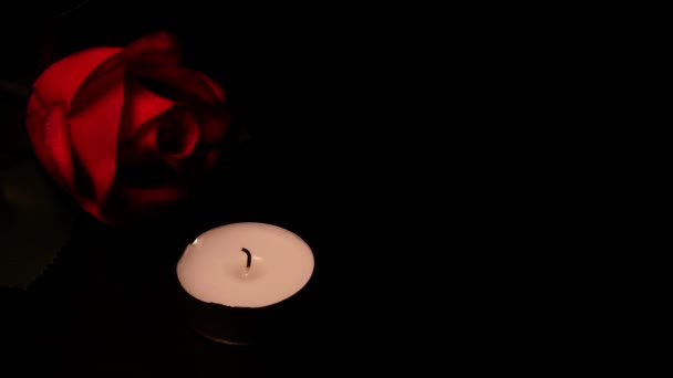 Roses and burning candles on black background as symbol mourning, memory or valentine day. — ストック動画