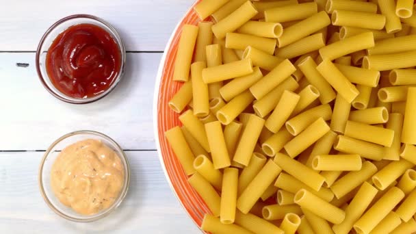 Pişmemiş çiğ italyan rigatoni makarnası. Tabakta yavaşça dönüyor.. — Stok video