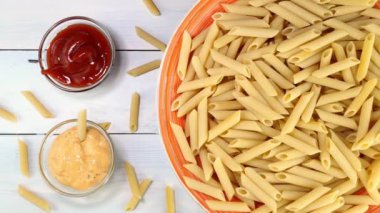 Pişmemiş çiğ İtalyan makarna. Tabakta yavaşça dönüyor..