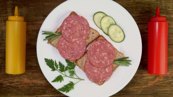 I sandwich di salame aperti con pane, cetriolo, prezzemolo su piatto bianco ruotano lentamente. — Video Stock
