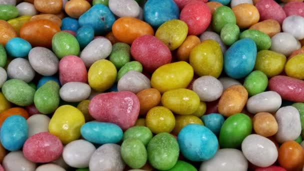 Pile of many round chewy candies dragee in multicolored glaze rotate slowly on turntable. — Vídeo de Stock