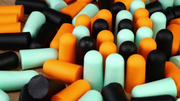 Heap many soft orange, blue and black earplugs protect against loud noise and help sleep peacefully. — Vídeos de Stock