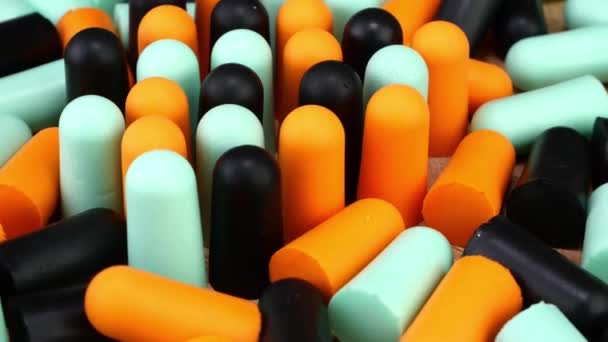 Heap many soft orange, blue and black earplugs protect against loud noise and help sleep peacefully. — Stock Video