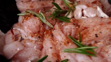Sliced pieces of chicken fillet, fried in pan in vegetable oil with rosemary and spices.