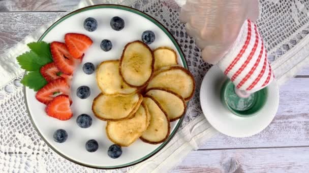 Stekta pannkakor på tallrik med jordgubbar, blåbär och vispgrädde roterar långsamt på skivtallriken. — Stockvideo