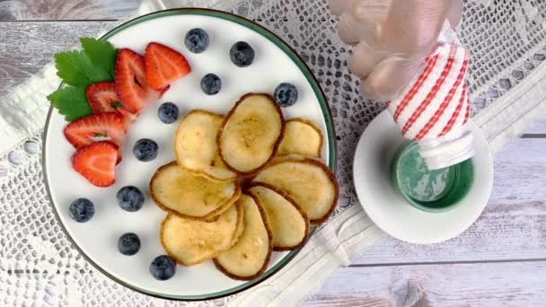 Stekta pannkakor på tallrik med jordgubbar, blåbär och vispgrädde roterar långsamt på skivtallriken. — Stockvideo
