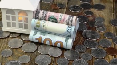 Amerikan dolarına yakın bir ev. Banknotlar boruya ve bir sürü bozuk paraya dönüştü. Gayrimenkul ve gayrimenkul yatırımları için ev parası ve mali varlıkların tasarrufu. Yakın plan..