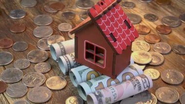 Ev, Amerikan dolarlarının üstüne yığılmış banknotlar ve bir sürü bozuk para. Gayrimenkul ve gayrimenkul yatırımları için ev parası ve mali varlıkların tasarrufu. Yakın plan..