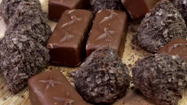 黒とミルクチョコレートのチョコレートお菓子キャンディーをゆっくりと回転させます 健康的でない甘い喜び — ストック動画