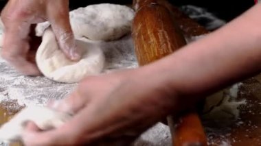 İnsan eli ekmek yapmak için taze hamur ya da ekmek pişirmek için mutfak tahtasına pizza koyar. Ev yapımı ev yapımı yemek pişirme. Kapat..
