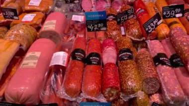 Kyiv, Ukraine, September 2022: - Different sausage types lying in display-type fridge on supermarket counter for sale. Grocery department on market showcase. Close up.