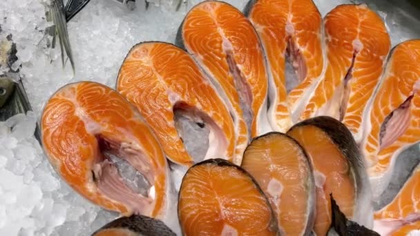 魚市場のアイスカウンターに寝そべっている生の新鮮な鮭のステーキフィレ シーフード市場で棚を開きます 閉じろ — ストック動画