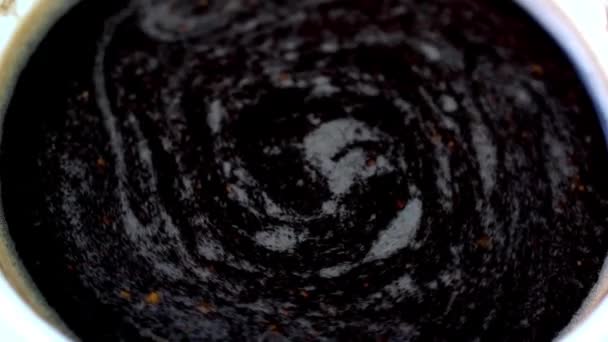咖啡泡沫与新鲜的黑咖啡在咖啡杯中旋转 搅拌后的咖啡表面 顶部视图 靠近点 — 图库视频影像
