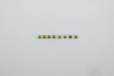 TROPICAL Kelime altın renkli bloklardan yapılır.