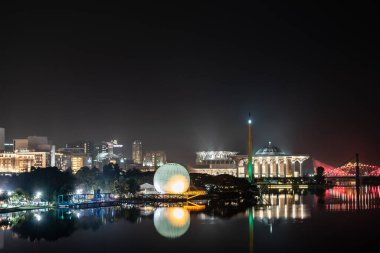 Renkli camili gece sahnesi, sıcak hava balonu ve Putrajaya, Malezya 'daki nehir yansımalı köprü..