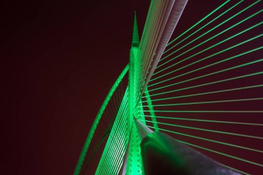 Putrajaya, Malezya 'daki modern köprü mimarisinin farklı renklerde gece görüşü.