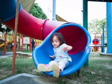 Asyalı çocuk sabah çocuk parkında kayıyor..