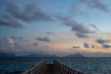 Borneo Sabah Semporna 'daki Bum bum adasının yakınındaki günbatımında tahta köprü..