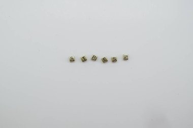 Beyaz zemin üzerinde altın zar bloklarıyla yazılan stres.