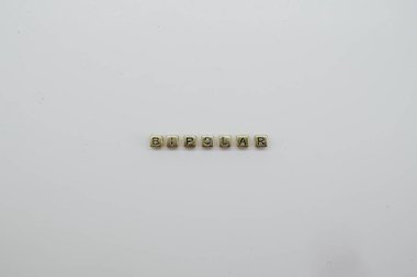 BIPOLAR kelimesi altın renkli bloklardan yapılmıştır.