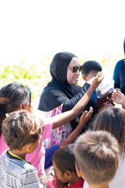 Sibuan, Malezya - 26 Kasım 2019: Köydeki Bajau Laut çocuklarına atıştırmalık ve mal dağıtan ziyaretçiler.