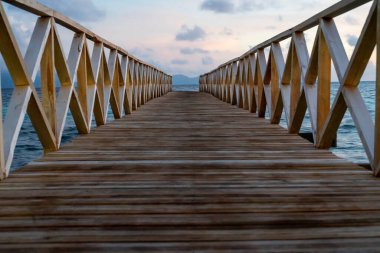 Borneo Sabah Semporna 'daki Bum bum adasının yakınındaki günbatımında tahta köprü..