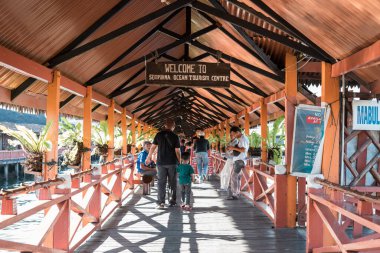 Semporna, Malezya - 28 Kasım 2019: Yerel turist, hatıra eşya satan bir yer olan Dragon Inn 'in girişinde yürüyor.