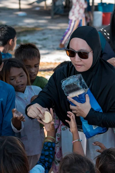 Sibuan, Malezya - 26 Kasım 2019: Köydeki Bajau Laut çocuklarına atıştırmalık ve mal dağıtan ziyaretçiler.