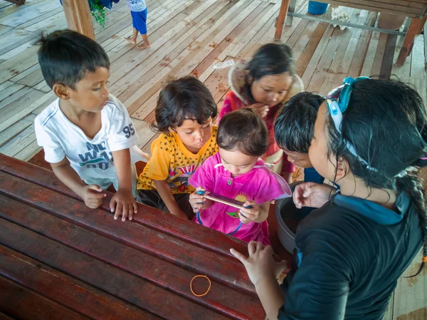 Semporna, Malezya - 26 Kasım 2019: Çocuklar cep telefonunda video izliyorlar. Teknoloji kullanan çocuklar.