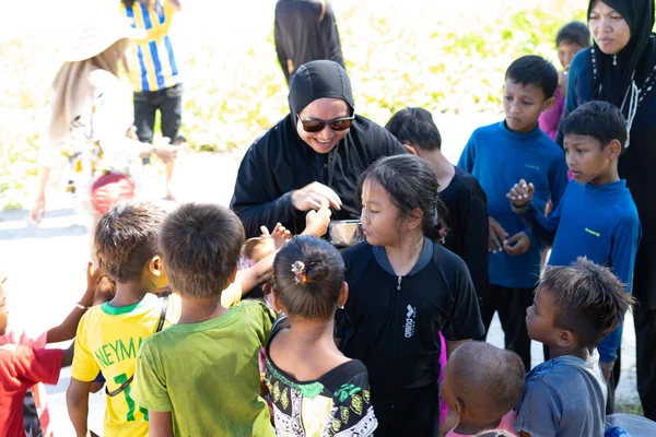 Sibuan, Malezya - 26 Kasım 2019: Köydeki Bajau Laut çocuklarına atıştırmalık ve mal dağıtan ziyaretçiler.