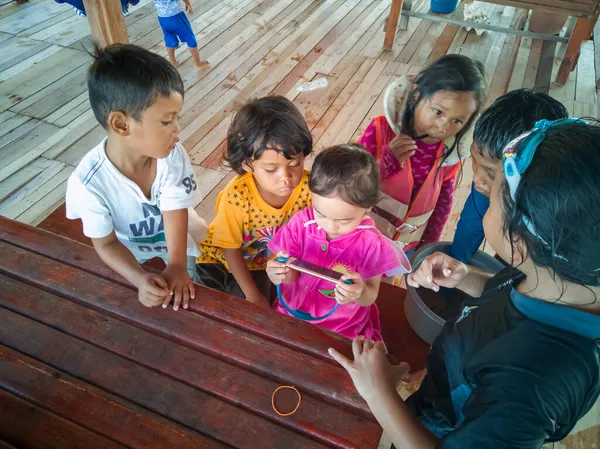 Semporna, Malezya - 26 Kasım 2019: Çocuklar cep telefonunda video izliyorlar. Teknoloji kullanan çocuklar.