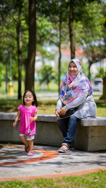 Müslüman anne ve kızı parkın merdivenlerinde, ailede, aşkta