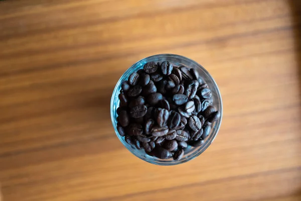 Bardaktaki Kahve Çekirdekleri Ahşap Arka Planda — Stok fotoğraf