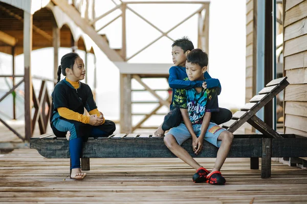 Semporna, Malezya - 25 Kasım 2019: Tahta sahil sandalyesinde oturan çocuklar.