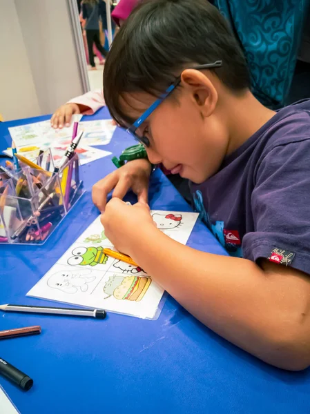 Kuala Lumpur, Malezya - Kasım 2019: Geri dönüşümlü plastik bir konteynır örtüsüne çizim yapan genç bir çocuğun yüksek açılı yakın çekimi. Anahtarlık yapıyorum..