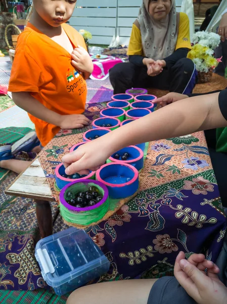Selangor, Malezya - 8 Aralık 2019: Bangi 'deki Taman Tasik Cempaka' da düzenlenen Majlis Perbandaran Kajang etkinliğinde geri dönüşümlü eşyalarla kongkak oynayan insanlar. Çevreye önem vermek.