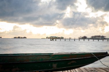 İskelede duran eski ahşap tekne güzel Semporna turkuaz denizine bakıyor..