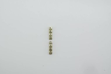 Keto diyeti beyaz arkaplanda altın zar bloklarıyla hecelenir.