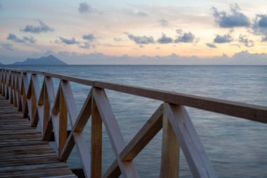 Borneo Sabah Semporna 'daki Bum bum adasının yakınındaki günbatımında tahta köprü..
