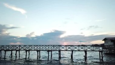 Semporna, Sabah Borneo, Malezya 'da güneş doğarken uzun tahta köprü boyunca yan doli.