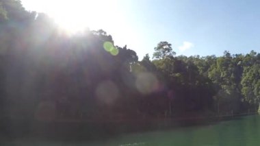 Güneş ışınları sabah görüntüsü teknenin içinden Kenyir Gölü yakınlarındaki doğa parkı, Malezya.