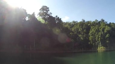 Güneş ışınları ve güzel sabah manzarası teknenin içinden Kenyir Gölü yakınlarındaki doğa parkı, Malezya.