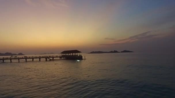 美しい日の出の間に背景に桟橋と島のビーチでの海の波のパノラマビュー — ストック動画