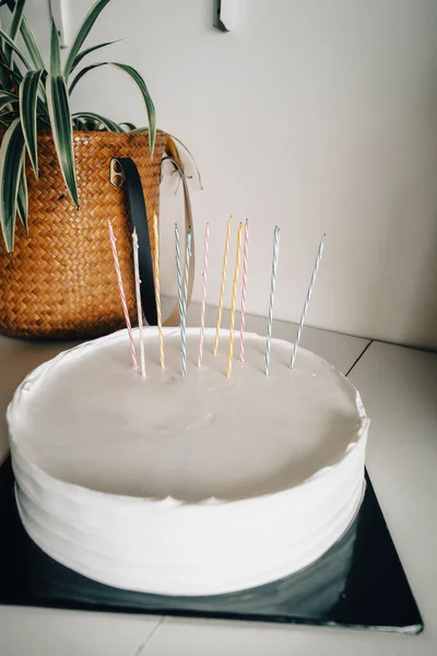 黒ケーキボードと木製の緑の背景にキャンドルと空白の背景スペースの白いケーキ 誕生日ケーキのモックアップ — ストック写真