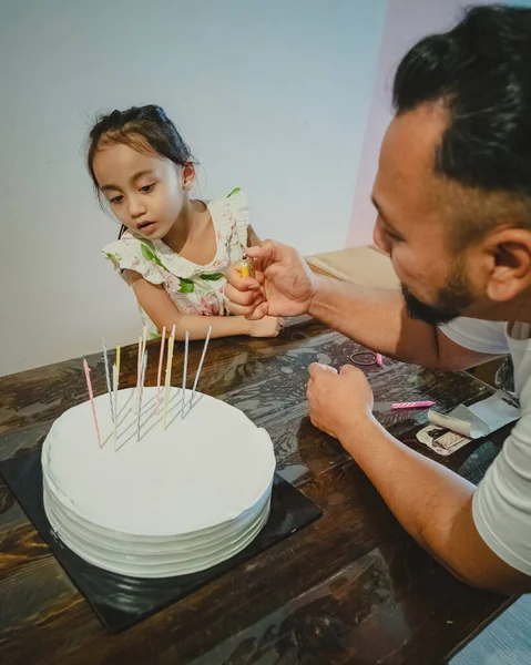 ライトキャンドルオン誕生日ケーキとともに女の子見る — ストック写真