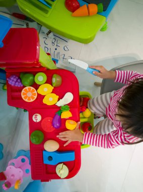 Yeni yürümeye başlayan çocuğun oyuncaklarıyla yemek pişirme görüntüsü..