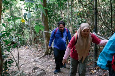 Dağlardaki bir grup insan, arka planda seyahat ediyorlar.
